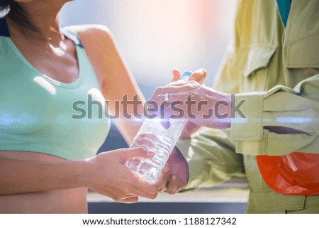 Lovers give water after exercise.engineer is caring for his wife. He is giving glass of water to her after run.