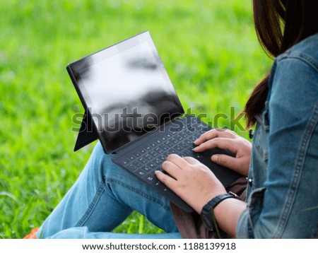 Rear view of girl working laptop and hands typing on the notebook keyboard