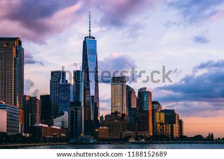 Panoramic view of Manhattan Island with sunset reflection in glass buildings.Scenery skyline view of contemporary skyscrapers of downtown financial district in New York. Gold sunset over NYC cityscape