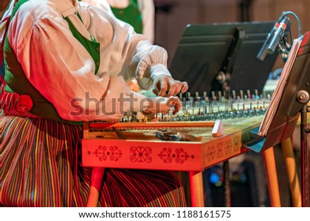 Hands playing on Kokle, a latvian plucked string instrument belonging to the Baltic box zither family Royalty-Free Stock Photo #1188161575