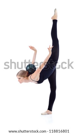 Graceful gymnast in black with ball on back stands on one leg, other leg held up poses isolated on white background.