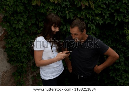 Man and woman laughing while watching pictures on the phone