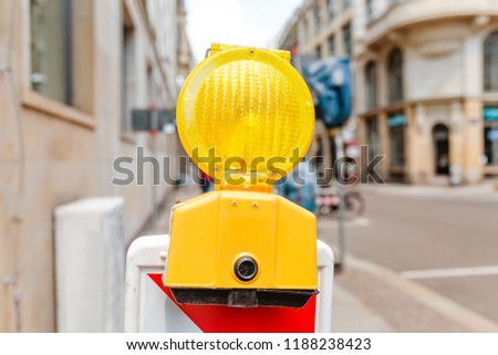 yellow signal lamp warning against a building construction site