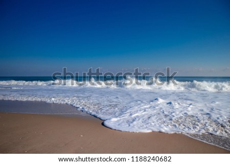 Smooth sand beach with tropical ocean and clam waves with blue sky on sunny day in Summer - Ocean City, Maryland USA Royalty-Free Stock Photo #1188240682