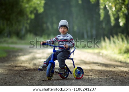 
the kid is riding a bicycle in the village