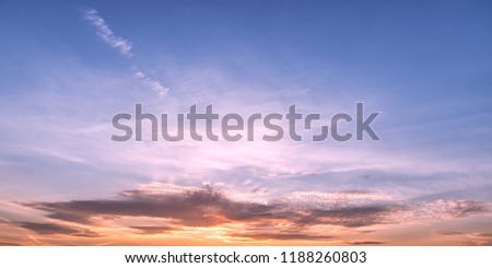 Pastel colored sunset sky panoramic view. Sun into clouds at golden hour