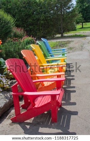 Multicolored, wooden, garden chairs in a row for display