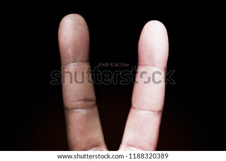 Photography idea showing a black and white finger making a peace sign against racism. Royalty-Free Stock Photo #1188320389