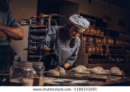 Cooking master class in bakery. Chef with his assistant showing ready samples of baking test in kitchen. Royalty-Free Stock Photo #1188333685