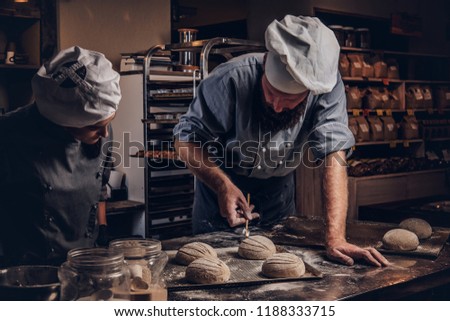 Cooking master class in bakery. Chef with his assistant showing ready samples of baking test in kitchen. Royalty-Free Stock Photo #1188333715