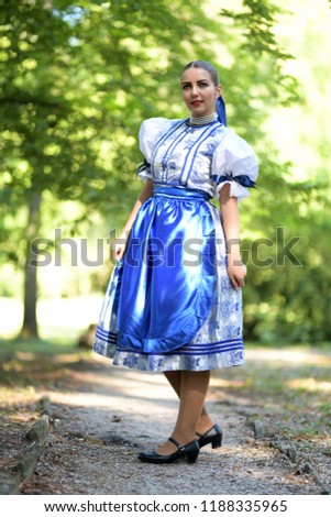 Young beautiful slovak woman in traditional costume on summer 