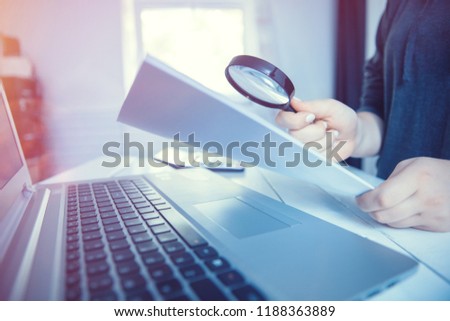 Woman holding magnifying glass over notebook, search concept.  Royalty-Free Stock Photo #1188363889