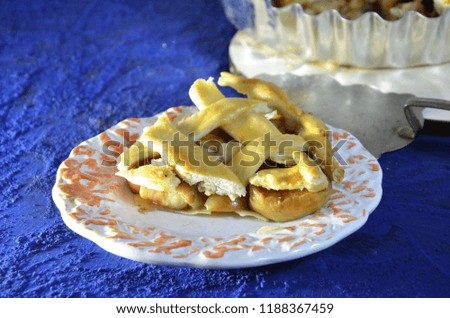 Whole apple pie, top view, a piece is taken out with a chrome cake server