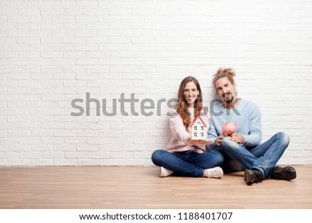 Happy young couple sitting on the floor of their new house. concept of love and moving house