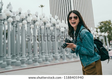 attractive female tourist holding the camera and taking photo of the Los Angeles county museum of art