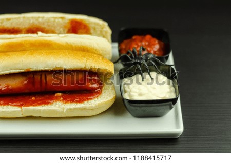 Creepy Halloween hotdog fingers on the black table, party food