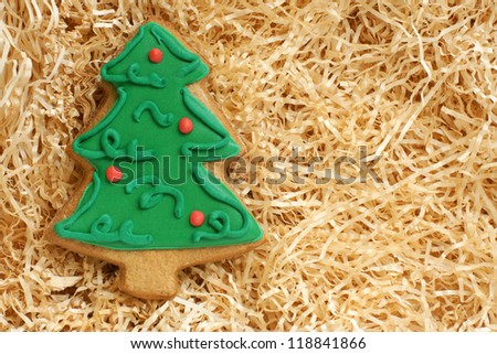 Christmas gingerbread cookie made in the shape of a Christmas tree on a paper shaving