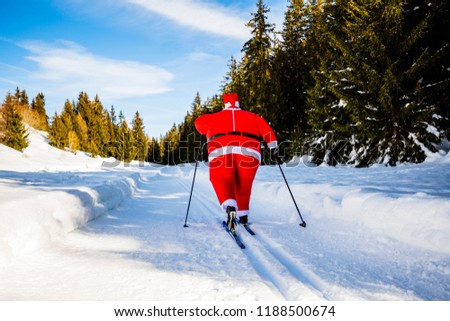Santa Claus with Christmas suits with classic  nordic ski in snowy winter mountain ski resort landscape in sunny day, New Year's or xmas is coming.
