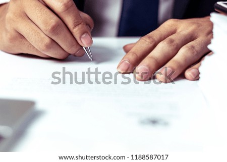 Businessman signing a document in office