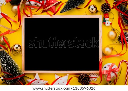 festive celebration background with christmas decorating items on yellow paper background with free copy space for your text