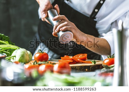 Chef cook preparing vegetables in his kitchen. Royalty-Free Stock Photo #1188599263