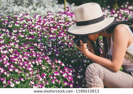 young beautiful girl tourist travel taking picture in flower garden.