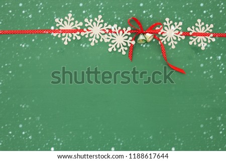 Christmas background with red silk traditional ribbon and white snowflakes