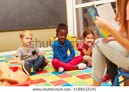 Group of children listen attentively while reading aloud from an exciting children's book