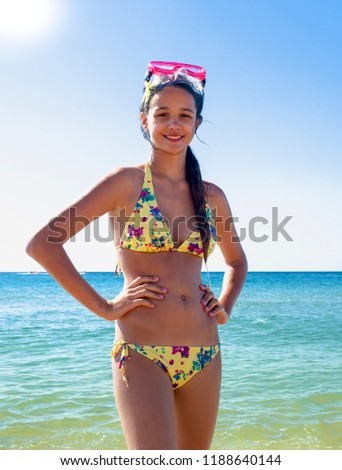 Beautiful girl playing on the sea, cute smiling in a mask for swimming