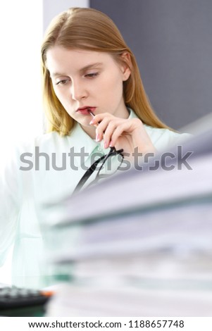 Bookkeeper or financial inspector woman making report, calculating or checking balance. Audit and tax service concept. Green colored image background 