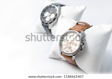 Watches white dial and brown stitched watch leather on a white background. Selective focus. Horizontal image.