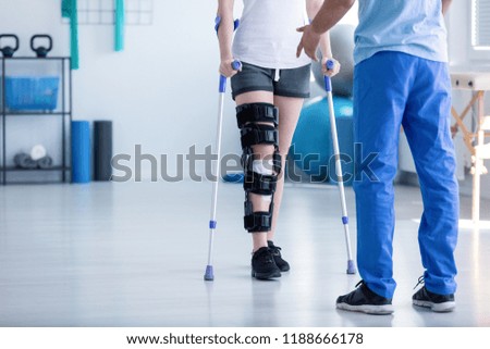 Professional physiotherapist supporting patient with orthopedic problem Royalty-Free Stock Photo #1188666178
