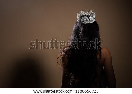 Portrait of Miss Pageant Beauty Contest in open back Evening fur Gown dress with sparkle light Diamond Crown, Asian Woman fashion make up black hair style, turn back side rear view no face Royalty-Free Stock Photo #1188666925