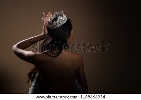 Portrait of Miss Pageant Beauty Contest in open back Evening fur Gown dress with sparkle light Diamond Crown, Asian Woman fashion make up black hair style, turn back side rear view no face Royalty-Free Stock Photo #1188666934