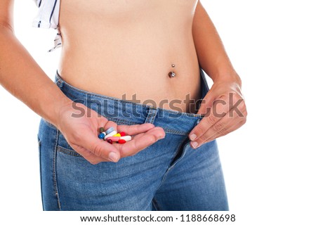 Close up picture of woman holding appetite suppressants - weight loss