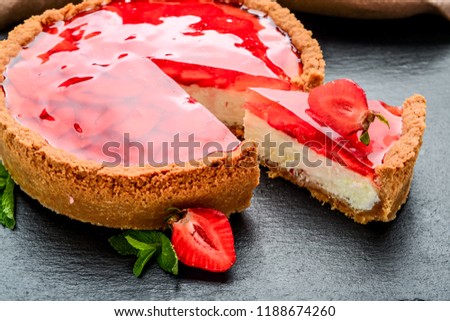 Cold cheesecake with strawberry and strawberry jelly. on the table