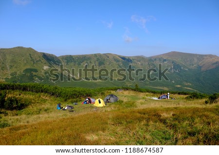 Awnings and tents in a camping in the background of the mountains