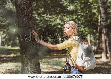 side view of young tourist with photo camera in park