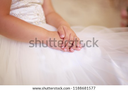 tender baby hands, girl in dress, tulle, closeup