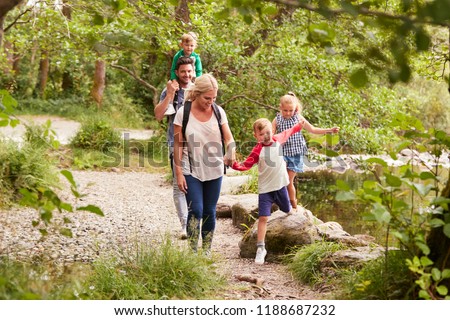 Family Hiking Along Path By River In UK Lake District Royalty-Free Stock Photo #1188687232