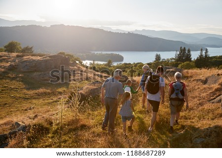 Rear View Of Multi Generation Family Walking On Top Of Hill On Hike Through Countryside In Lake District UK Royalty-Free Stock Photo #1188687289