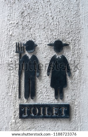 Close up vintage toilet sign on raw concrete wall background