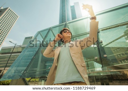 Man makes selfie in the big city against the background of skyscrapers. Travel and life style concept.