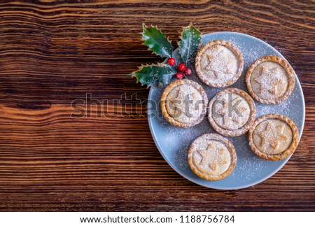 A blue plate with homemade, fresh British Mince Pies for Christmas on a wooden table