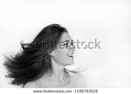 portrait of a beautiful cheerful girl with freckles on her face and a charming smile, dancing and whirling, with long flowing hair. people, lifestyle, sport, dance, happiness concept