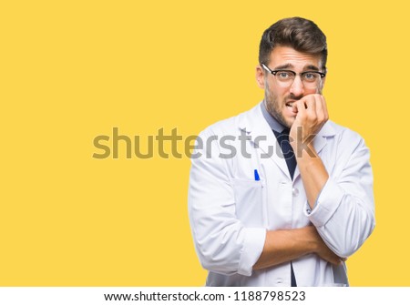 Young handsome man wearing doctor, scientis coat over isolated background looking stressed and nervous with hands on mouth biting nails. Anxiety problem.