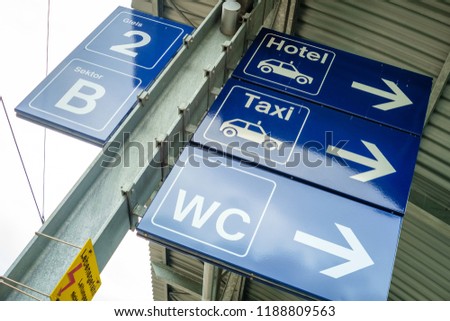 A blue sign is indicating where the bathroom at the railway station of the Swiss village of Wengen (Berner Oberland) and the hotel's and taxi's are located.