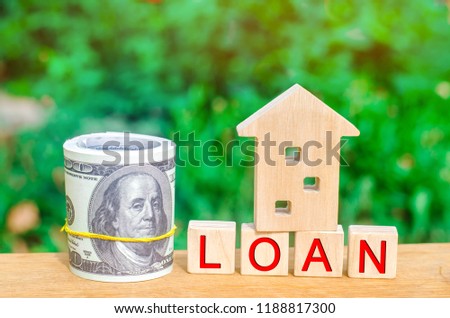 Model of the house, money and the inscription "Loan". Buying a home in debt. Family investment in real estate and risk management concept. Loan for a mortgage. apartment rental sale buy