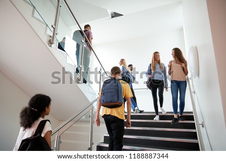 High School Students Walking On Stairs Between Lessons In Busy College Building Royalty-Free Stock Photo #1188887344