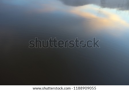  pine forest island and shrubs refection on the lake at dawn with magic of the sky and clouds